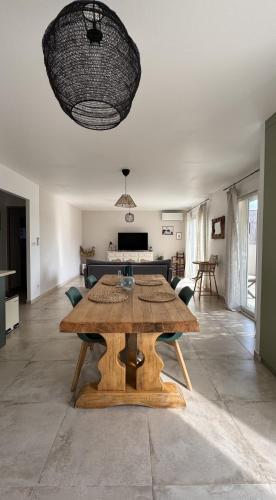 - une table en bois dans une chambre avec un salon dans l'établissement La Farigoule - Villa avec spa, clim, terrasse, à La Roque-sur-Cèze