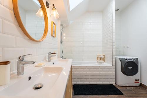 une salle de bain blanche avec un lavabo et un miroir dans l'établissement Maison de ville pour 10 personnes près Disney & Paris, à Montévrain