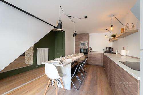 une cuisine avec une grande table à manger et des chaises blanches dans l'établissement Maison de ville pour 10 personnes près Disney & Paris, à Montévrain