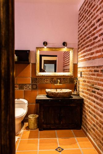 a bathroom with a sink and a mirror and a toilet at Casa de hospedaje -La Abadía de San Pedro in Guadalajara