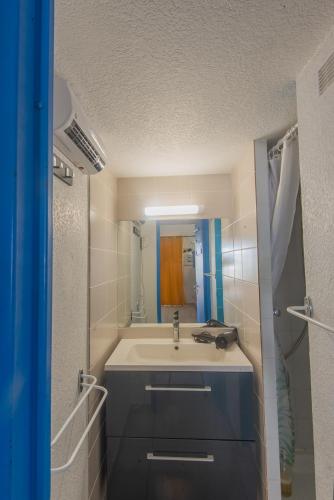 une salle de bain avec un lavabo et un miroir dans l'établissement maison 6-8 personnes, 3 étoiles, au Cap d'Agde