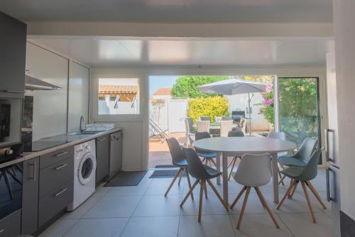 Il dispose d'une terrasse et d'une cuisine avec une table et des chaises. dans l'établissement maison 6-8 personnes, 3 étoiles, au Cap d'Agde