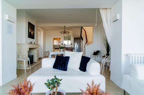 a living room with a white couch and a fireplace at Villa Bellevue 10 Personnes in Arromanches-les-Bains