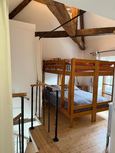 2 letti a castello in una camera con soffitti in legno di Cedar Cottage - Disney 30min a Coulommiers