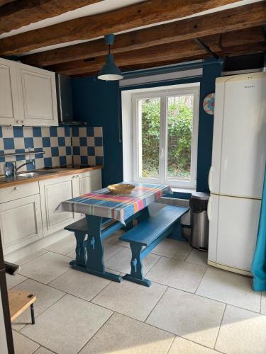 une cuisine avec une table et une fenêtre. dans l'établissement Cedar Cottage - Disney 30min, à Coulommiers