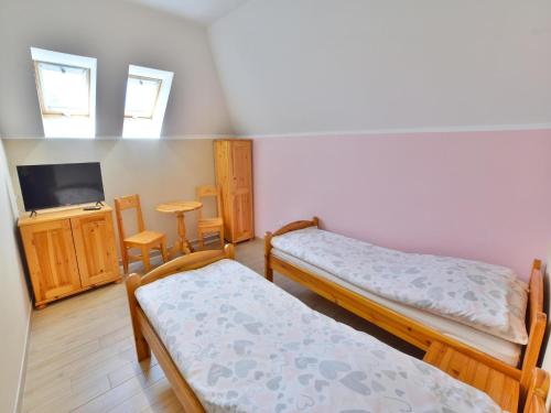 a room with two beds and a tv at Holiday apartment, 3 bedrooms, garden, S owino in Słowino