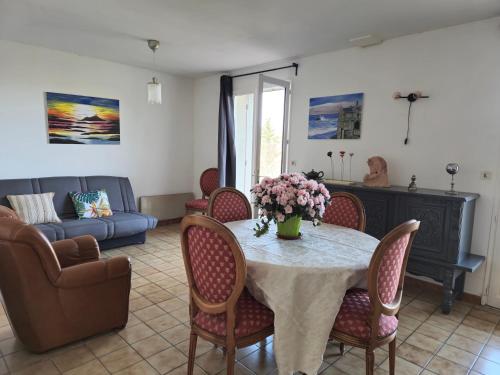 un salon avec une table, des chaises et un canapé dans l'établissement Villa plain pied avec vue imprenable, à Martres-de-Veyre