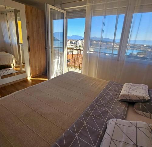 a bedroom with a large bed with a large window at The View in Ploče