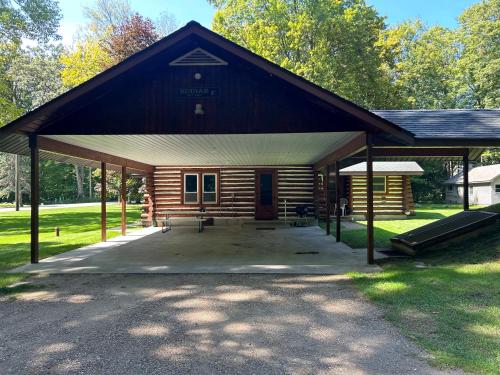a log cabin with a pavilion in a park at Lake Access! Twin Birch Resort - Kodiak Cabin in Honor