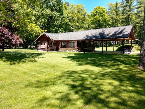 a log cabin in a park with a large yard at Lake Access! Twin Birch Resort - Kodiak Cabin in Honor