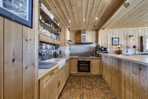 une grande cuisine avec des placards en bois et un évier dans l'établissement Résidence Combe Folle - Appartement spacieux · Balcon · Wifi MAE-9561, à Tignes