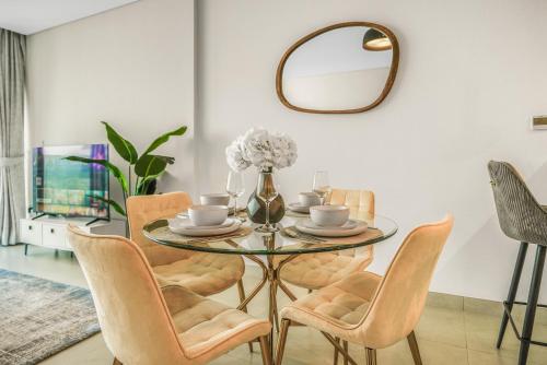 a dining room with a glass table and chairs at Sea View Apartment located on the 39th floor with rooftop pool close to world trade centre in Dubai
