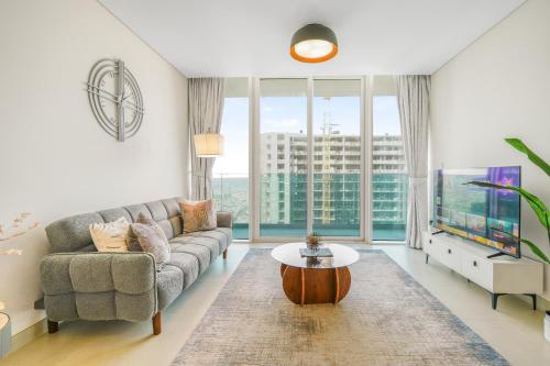 a living room with a couch and a table at Sea View Apartment located on the 39th floor with rooftop pool close to world trade centre in Dubai