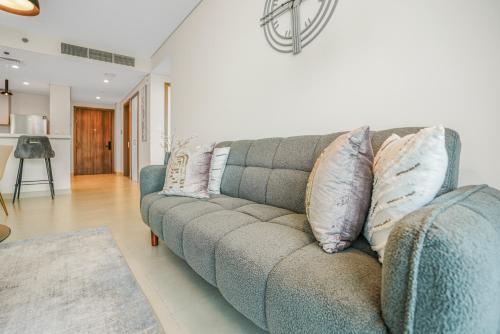 a couch in a living room with pillows on it at Sea View Apartment located on the 39th floor with rooftop pool close to world trade centre in Dubai