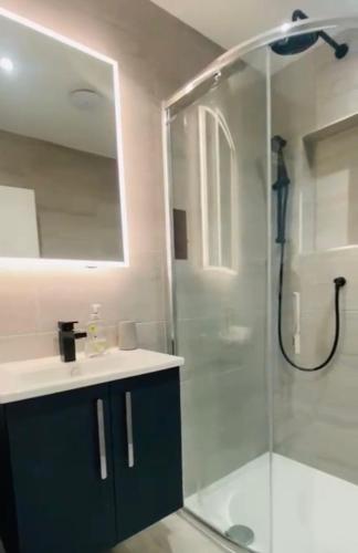 a bathroom with a glass shower and a sink at Brean & Berrow Rooms in Berrow
