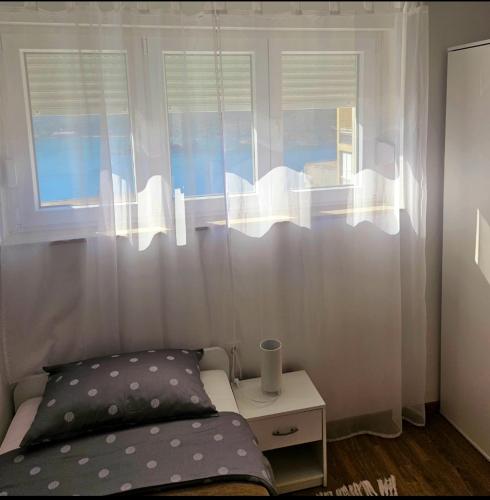 a bedroom with a bed and a window with curtains at The View in Ploče