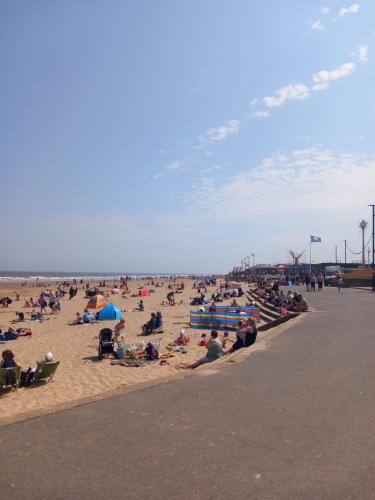 a crowd of people sitting on the beach at H21 holiday let in Mablethorpe