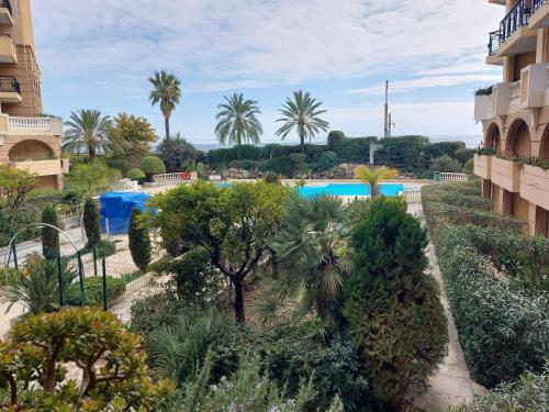 - une vue sur un complexe avec des arbres et une piscine dans l'établissement CARIBOU T2 piscine - Axelle Loc'Appart, à Cannes