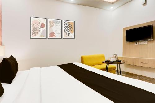 a hotel room with a bed and a tv at Super Townhouse Eden Garden Zirakpur in Zirakpur