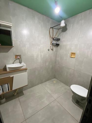 a bathroom with a toilet and a sink at Aconchego ao pé da serra in São Roque de Minas