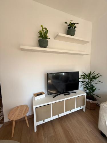 a living room with a flat screen tv on a white cabinet at THdue in Golasecca