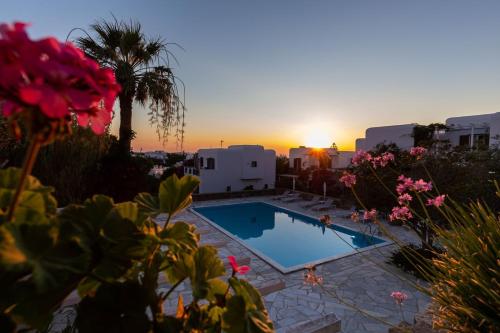 a swimming pool with a sunset in the background at Private Town Apartments by Mykonos Eight in Mýkonos City