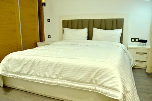 a large white bed with white sheets and pillows at Hivernage Residence, Modern 2 Bedroom in Agadir