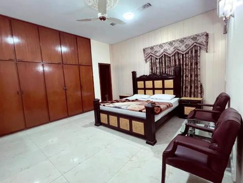 a bedroom with a bed and a chair at Hotel Royal one in Lahore