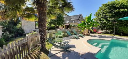 une cour avec une piscine, des chaises et une clôture dans l'établissement Maison traditionnelle avec piscine, à Gourdon