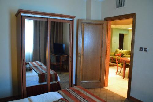 a bedroom with a door open to a room with a bed at فندق أميري سويت in Umm Uthainah