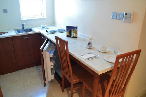 a kitchen with a table with two chairs and a sink at فندق أميري سويت in Umm Uthainah