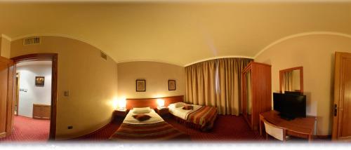 a hotel room with two beds and a television at فندق أميري سويت in Umm Uthainah