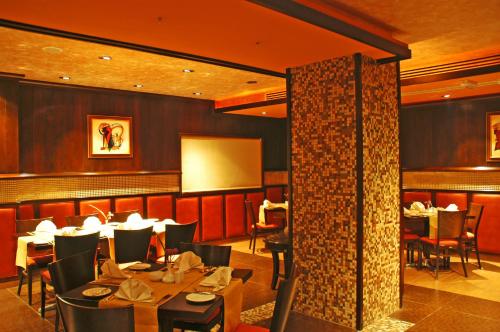 a restaurant with tables and chairs in a room at فندق أميري سويت in Umm Uthainah