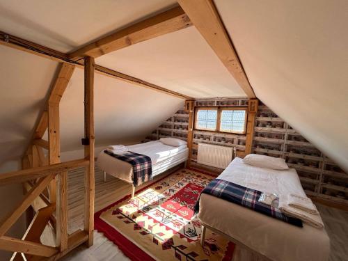 a attic room with two beds and a rug at Hnameni Bovadzor Lodge in Maksim Gorʼkiy