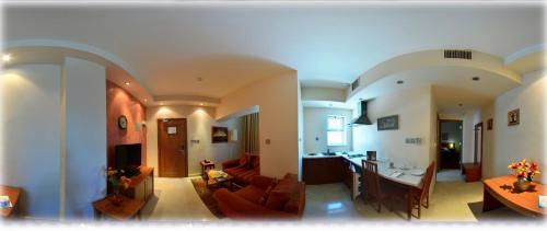 a living room and a kitchen with a couch and a table at فندق أميري سويت in Umm Uthainah