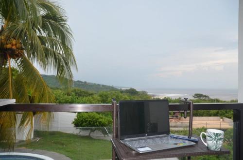 a laptop computer sitting on a table on a balcony at Loft in the heart of El Sunzal in Tamanique