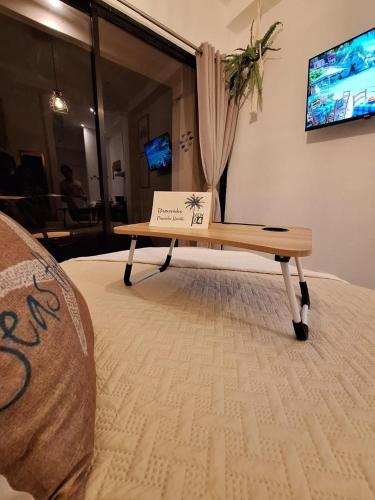 a table with a sign on top of a bed at Loft in the heart of El Sunzal in Tamanique