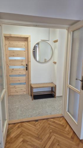 a room with a mirror and a door with a bench at Apartmán pri mlyne in Nové Zámky