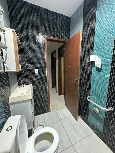 a bathroom with a toilet and a walk in shower at Beach House Cabo Frio Hostel in Cabo Frio