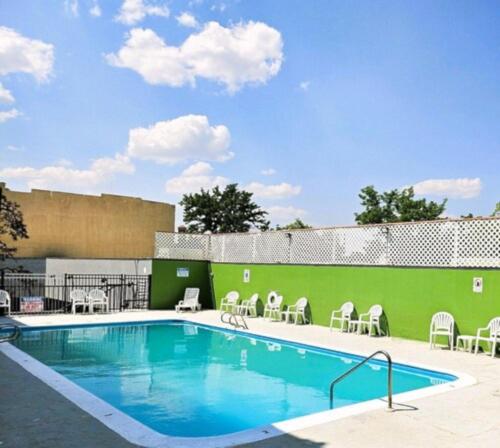 a swimming pool with tables and chairs next to a building at Super 8 by Wyndham Great Falls City Center in Great Falls