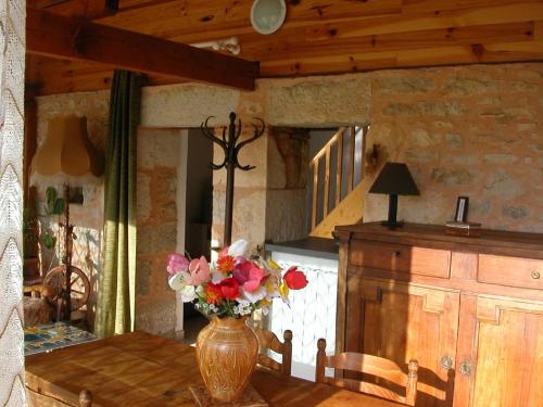 a vase of flowers on a table in a room at Hameau les Combelles in Martel