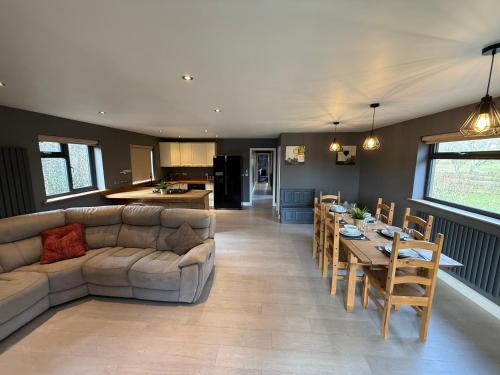 a living room with a couch and a table at 3 Bed Luxury Lodge in Sherfield English