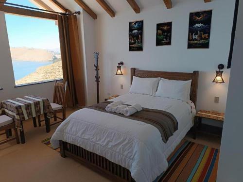 a bedroom with a large bed and a large window at Sol y Luna - ISLA DEL SOL in Comunidad Yumani