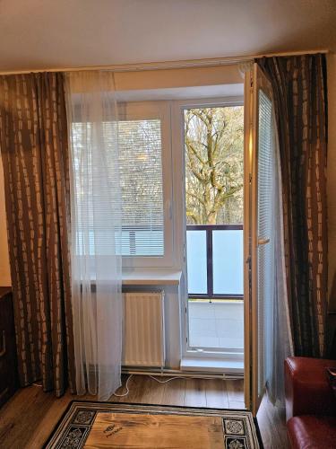 a living room with a large window with curtains at MK Apartment Hron in Podbrezová