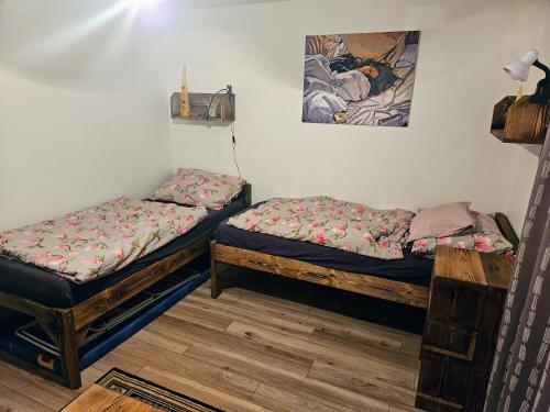 two twin beds in a room with a picture on the wall at MK Apartment Hron in Podbrezová