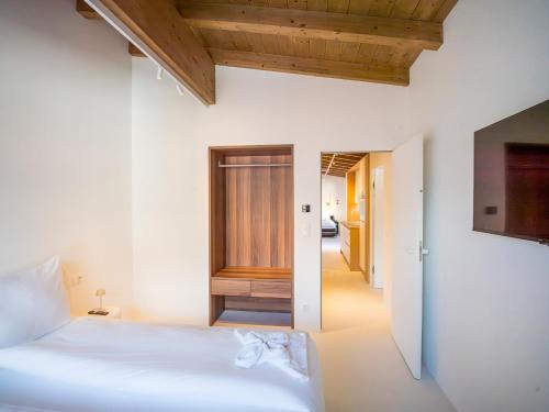 a bedroom with a white bed and a hallway at PENTHOUSE N`1 - Stylish Apartment with Rooftop Whirlpool Access in Tyrol, presented by AlpenLuxus in Kramsach