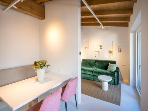 a living room with a green couch and pink chairs at PENTHOUSE N`1 - Stylish Apartment with Rooftop Whirlpool Access in Tyrol, presented by AlpenLuxus in Kramsach