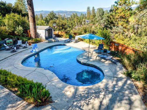 Una vista aérea de una piscina con una sombrilla. en Spacious Mountain View Oasis - Pool, Spa & Game Rm, en Oakhurst