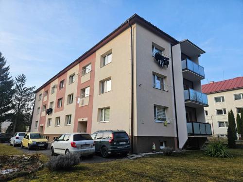 a building with cars parked in front of it at MK Apartment Hron in Podbrezová