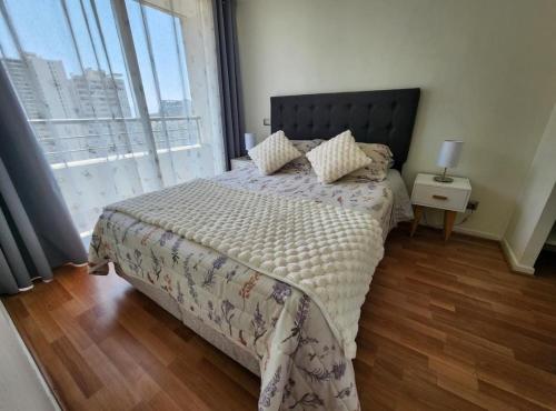 a bedroom with a bed and a large window at Céntrico y lindo departamento in Santiago
